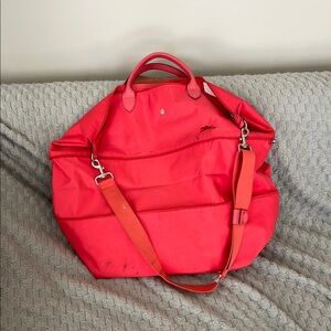 Longchamp Red Travel Bag with Glossy Finish and Versatile Straps